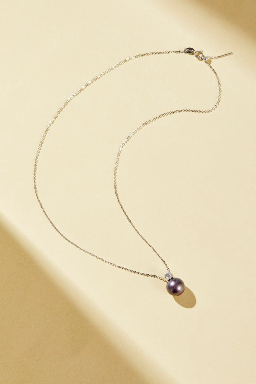 Purple iridescent pearl pendant with single CZ accent close-up