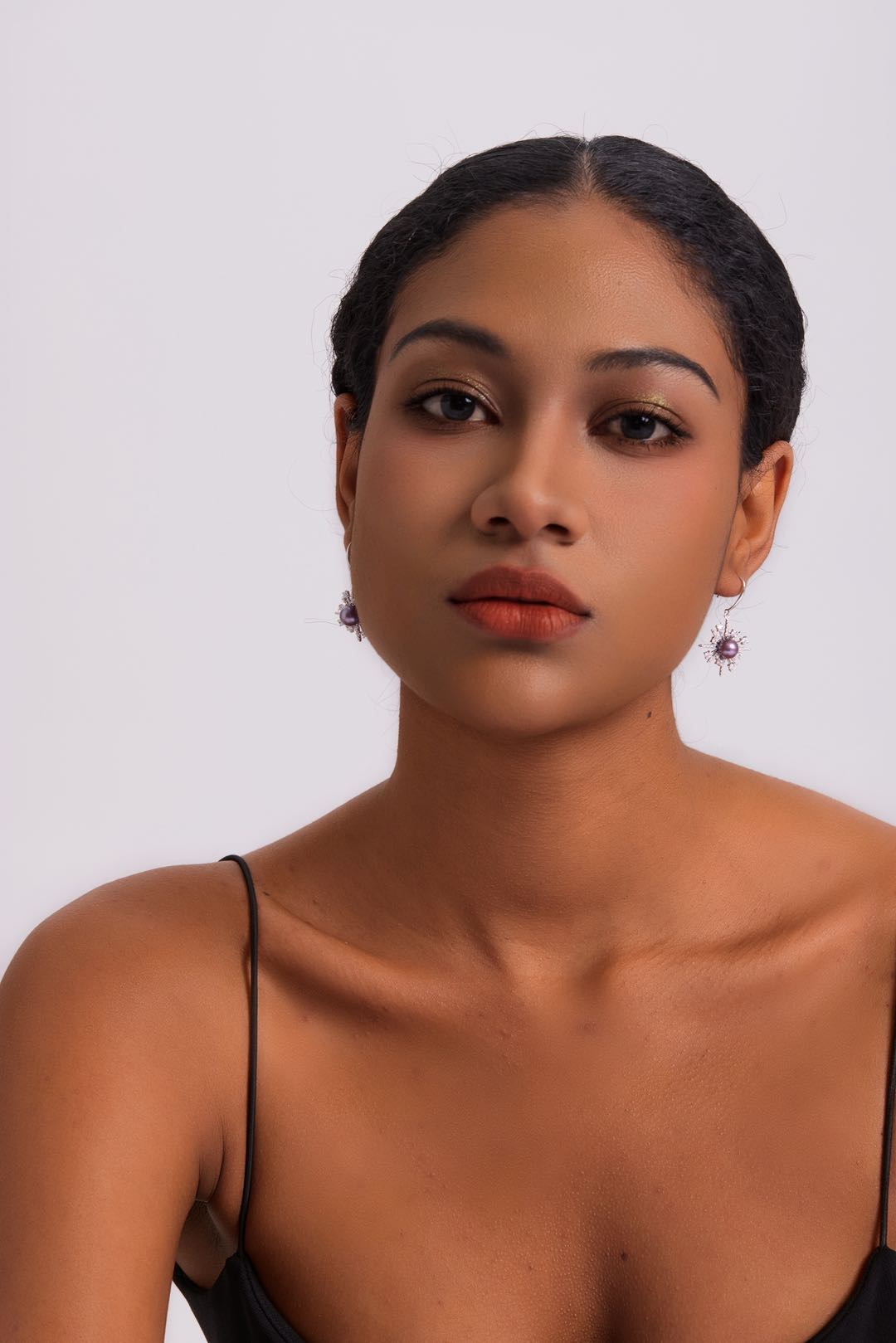 Model wearing Stellar Frost purple pearl drop earrings, elegant evening look