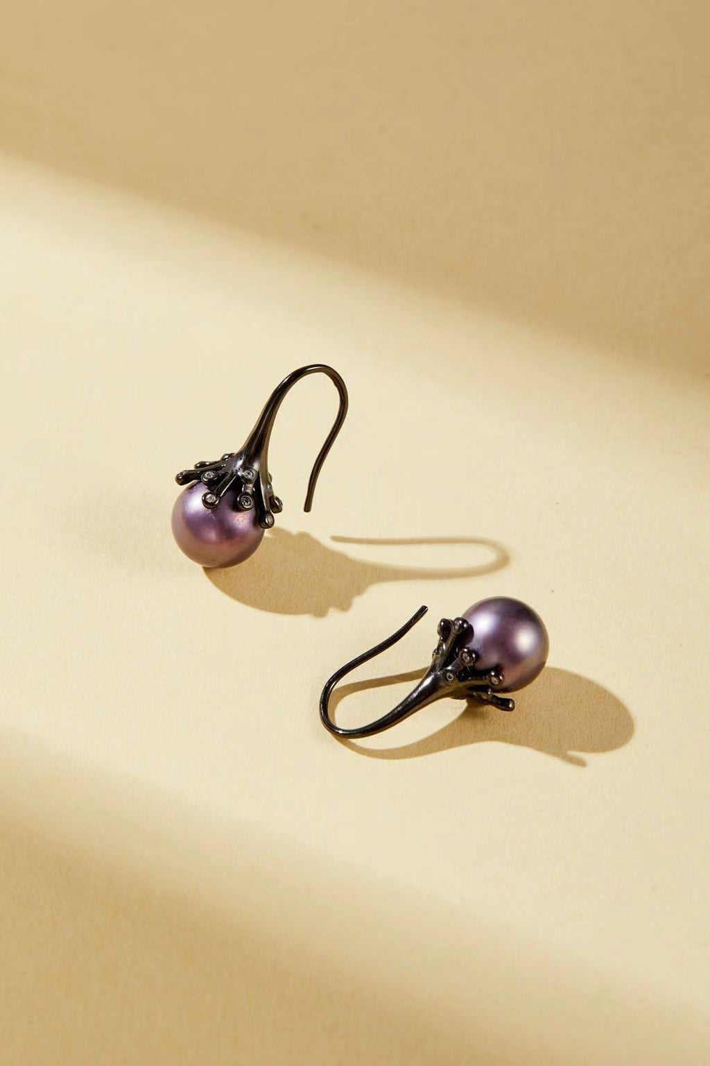 Purple iridescent pearl with dark alloy bud design close-up