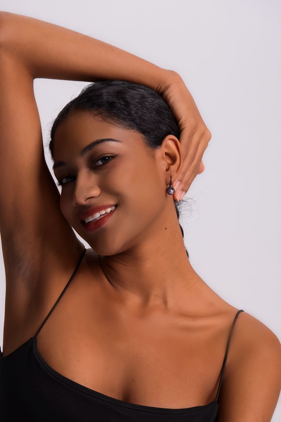 Model wearing Midnight Bloom purple pearl drop earrings with black outfit