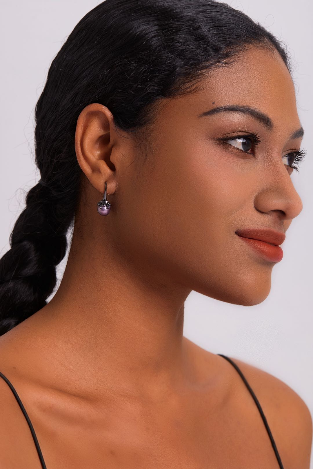 Model wearing Midnight Bloom purple pearl drop earrings with black outfit