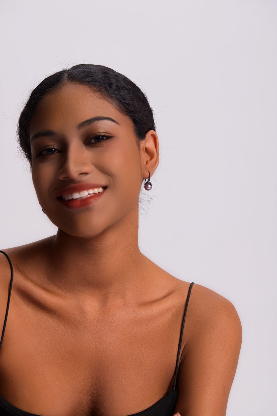 Model wearing Midnight Bloom purple pearl drop earrings with black outfit