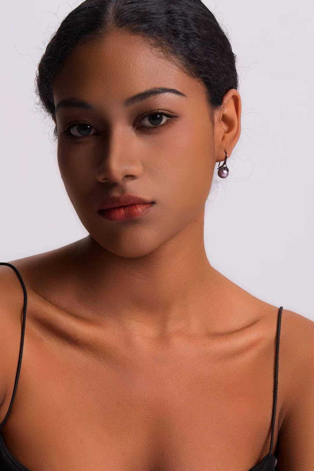 Model wearing Midnight Bloom purple pearl drop earrings with black outfit