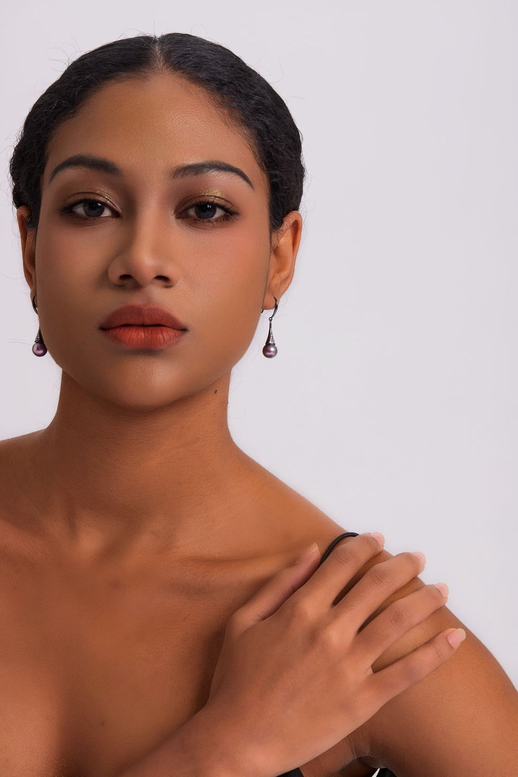 Model wearing Midnight Bloom purple pearl drop earrings with black outfit