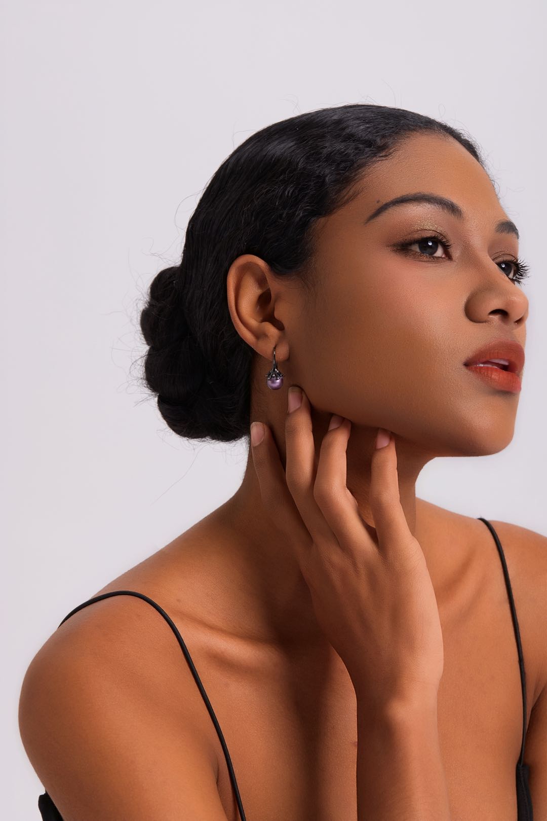 Model wearing Midnight Bloom purple pearl drop earrings with black outfit