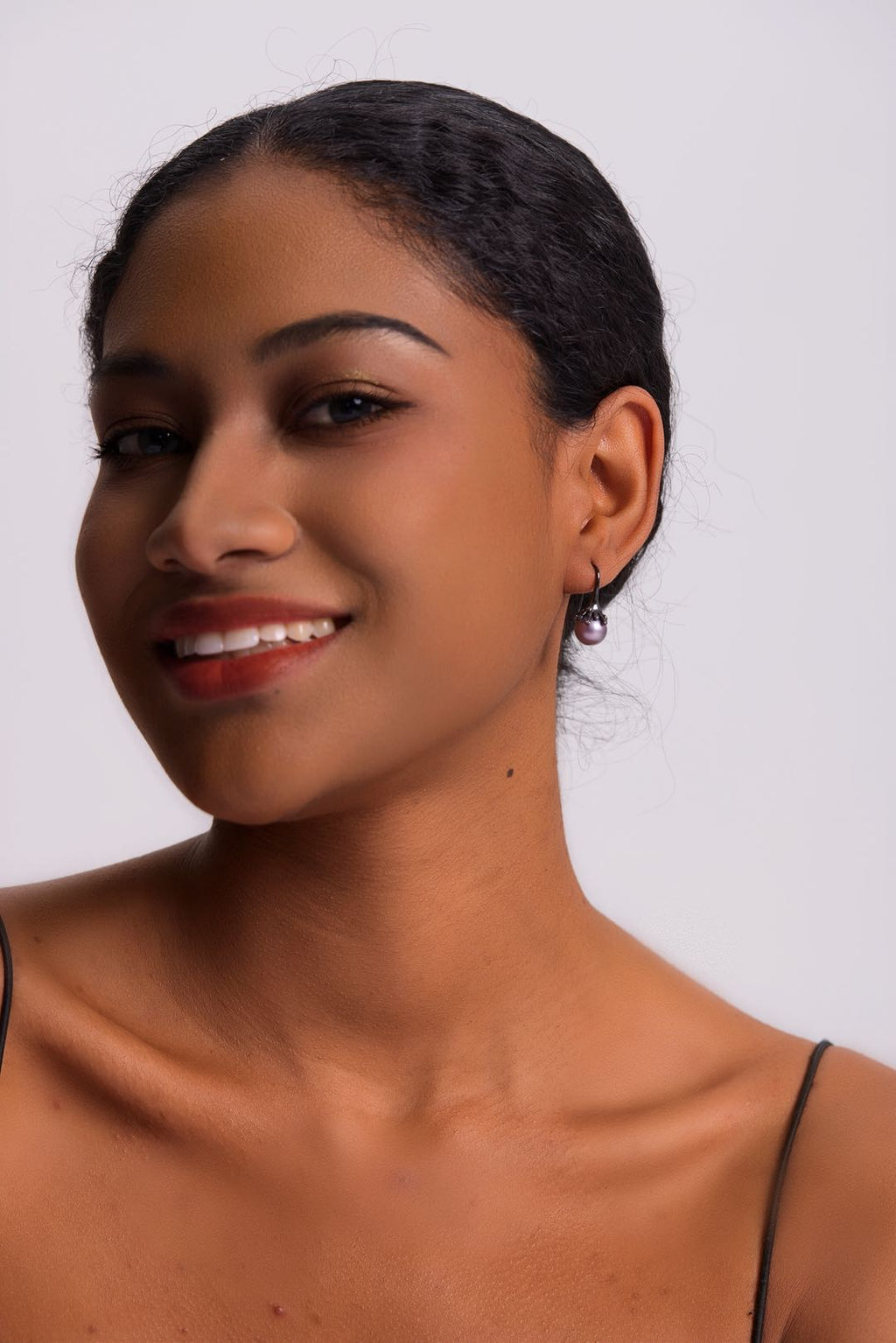 Model wearing Midnight Bloom purple pearl drop earrings with black outfit