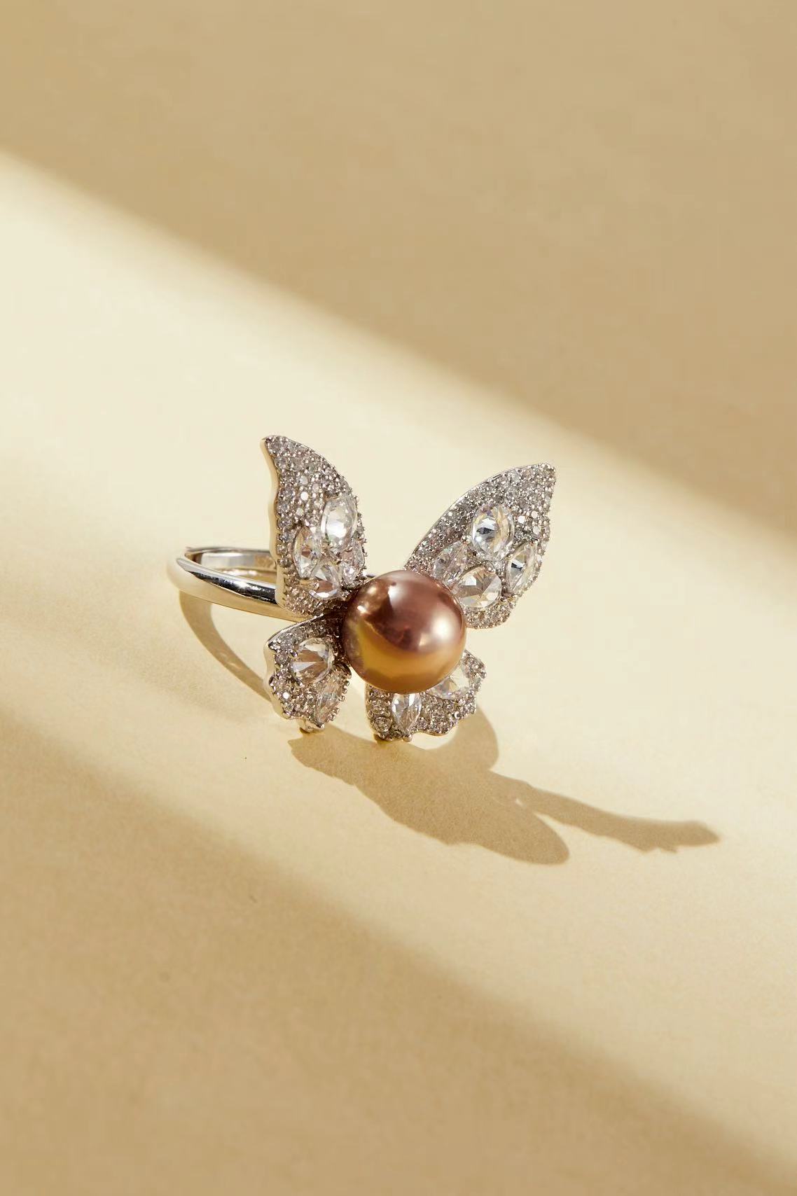 Pink fashion pearl with sparkling CZ butterfly wing design close-up