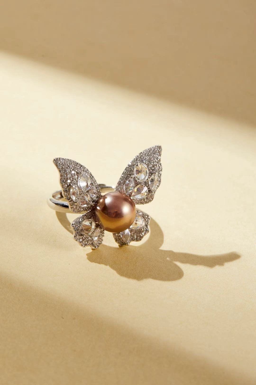 Pink fashion pearl with sparkling CZ butterfly wing design close-up