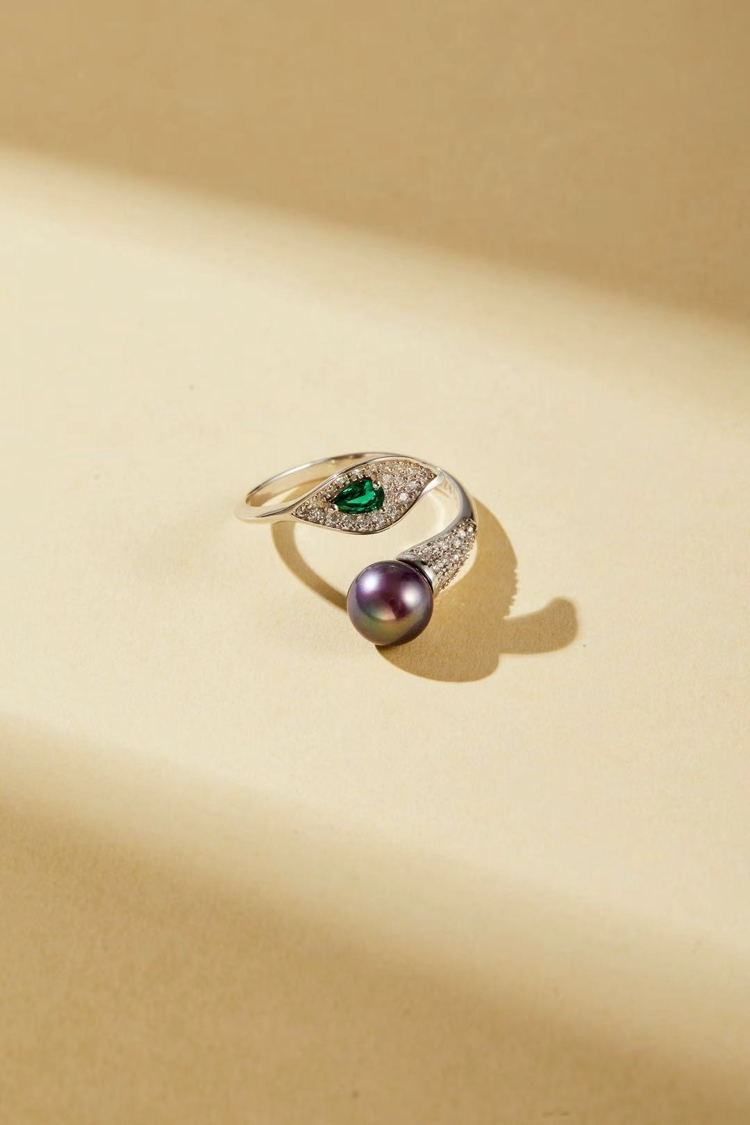 Purple fashion pearl and green teardrop cubic zirconia bypass ring close-up
